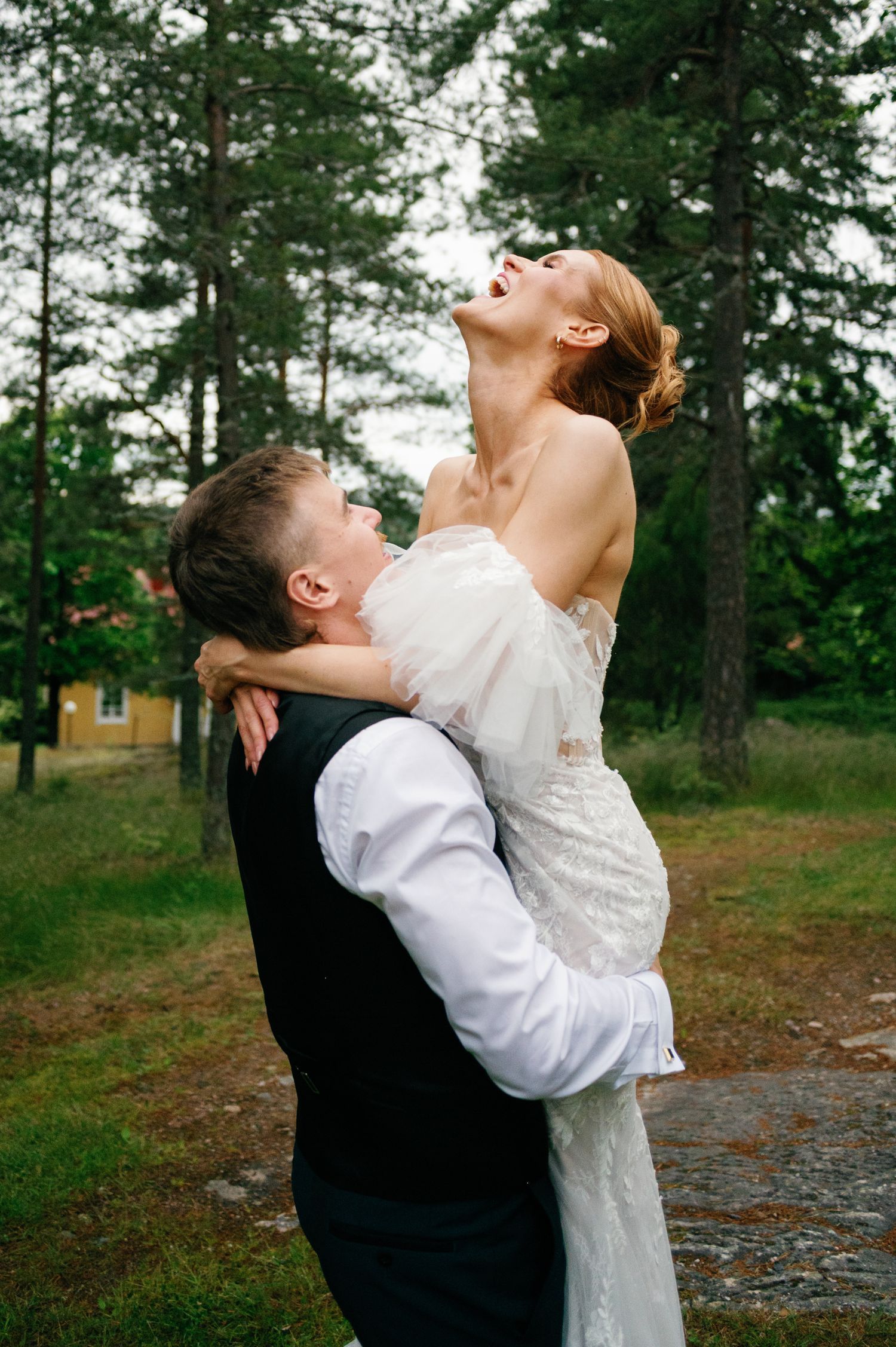 Joyful wedding couple embracing in a natural forest setting.