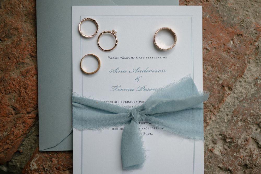 Wedding invitation suite featuring pale blue ribbon and elegant typography.