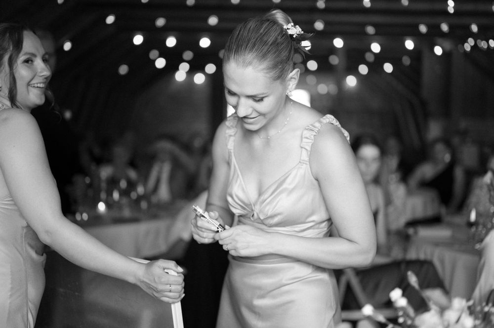 Candid black and white photo of wedding reception dancing and celebrations.