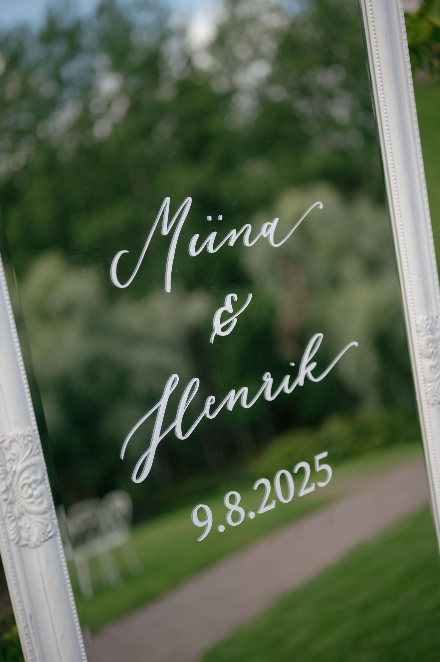Elegant white framed wedding signage with handwritten text showing a date of 9.8.2025.