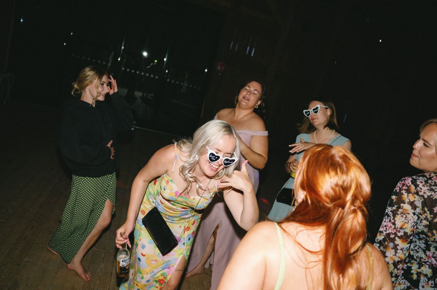 Festive wedding reception with guests dancing under ambient lighting.