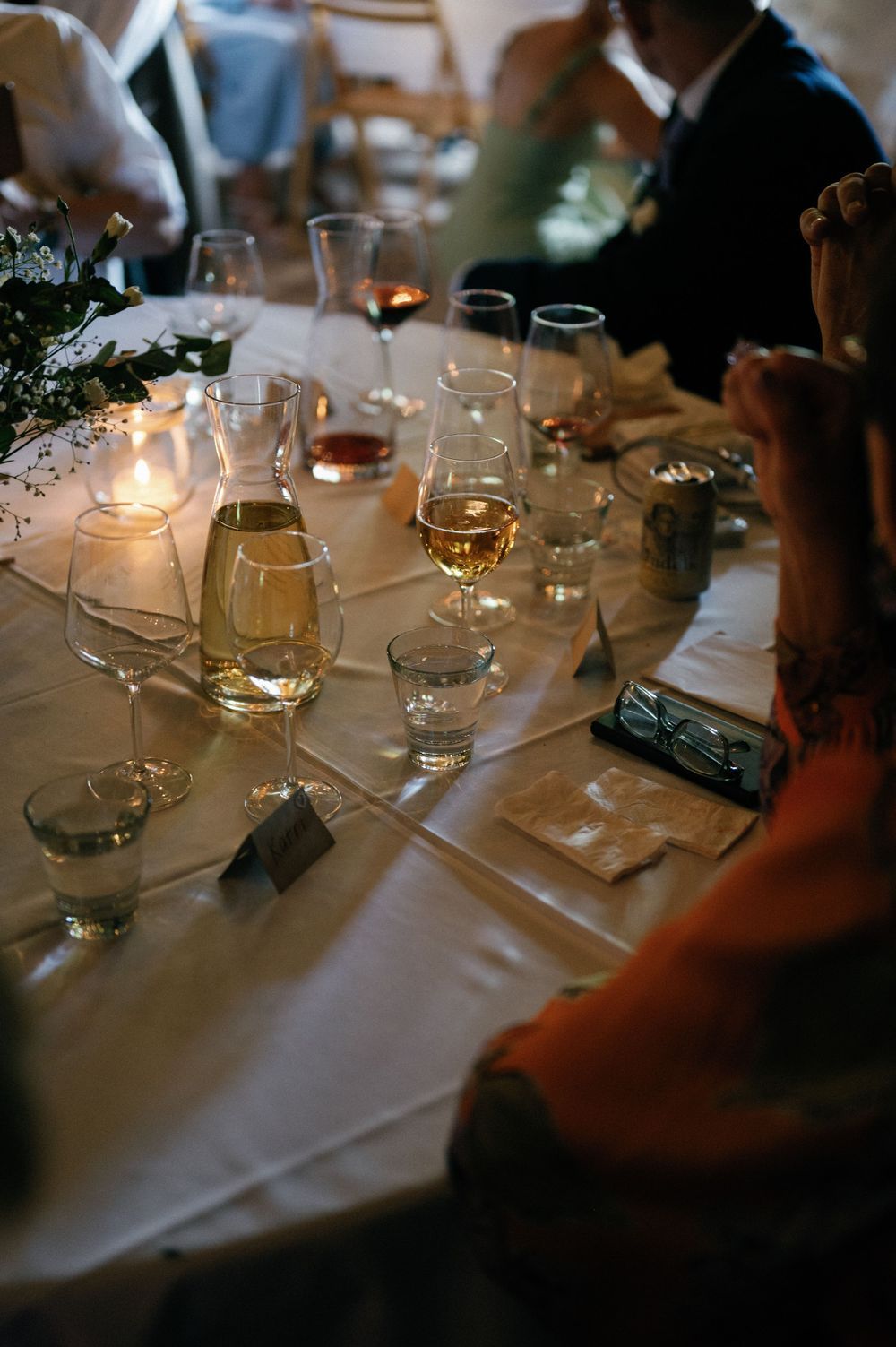 Wedding reception table set with wine glasses, candles and elegant place settings.