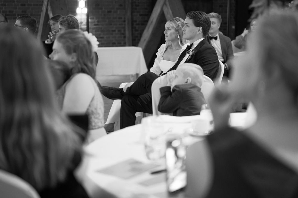 Wedding reception guests enjoying a formal dinner in an elegant brick venue.