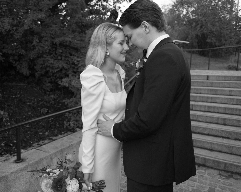 Black and white wedding photo series showing romantic moments between newlyweds on outdoor stone steps.