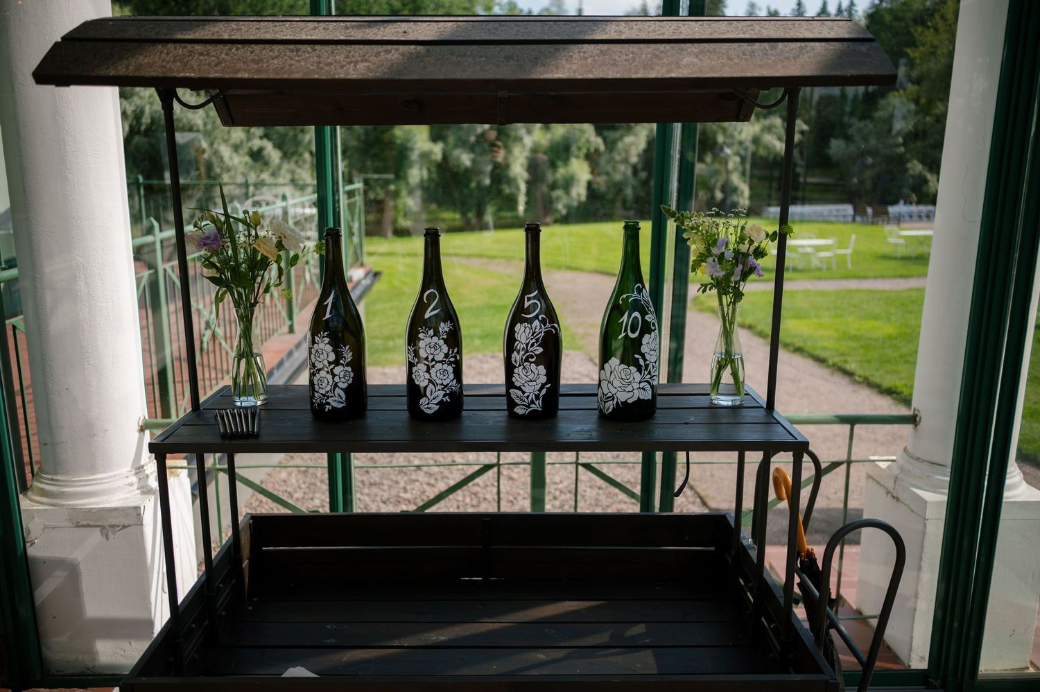 Panoramic view of a covered porch with white columns overlooking a green landscape.