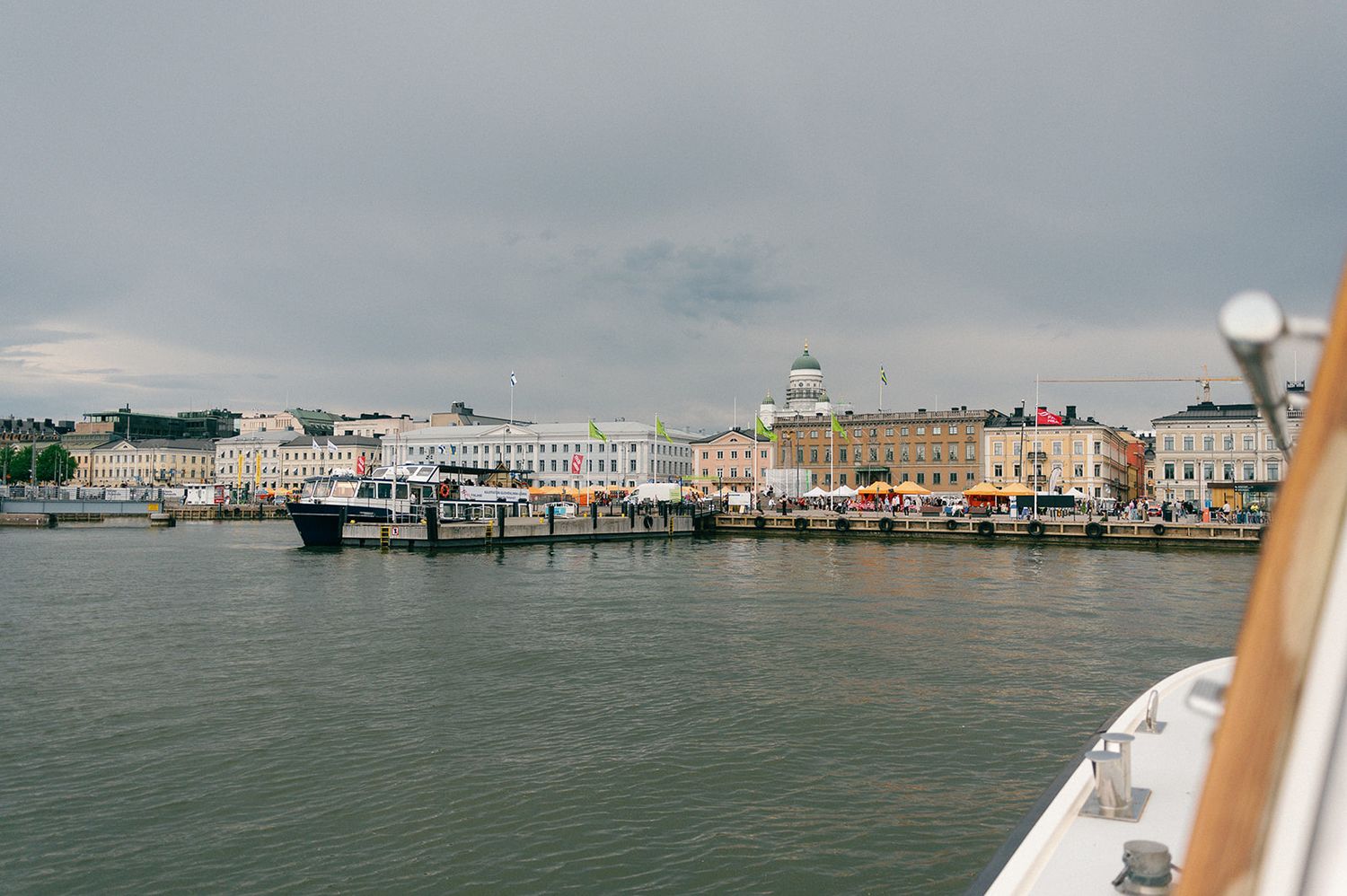 Waterfront view of historic buildings and pier from a boat perspective.