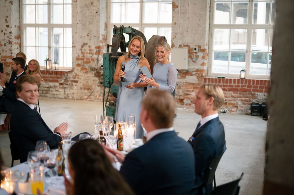 Wedding celebration in an industrial venue with exposed brick walls and large windows.