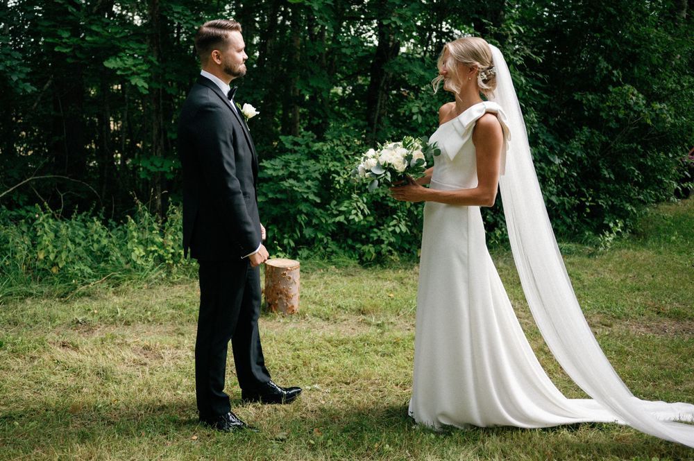 Wedding couple shares intimate moments in an outdoor garden setting with brick building backdrop.