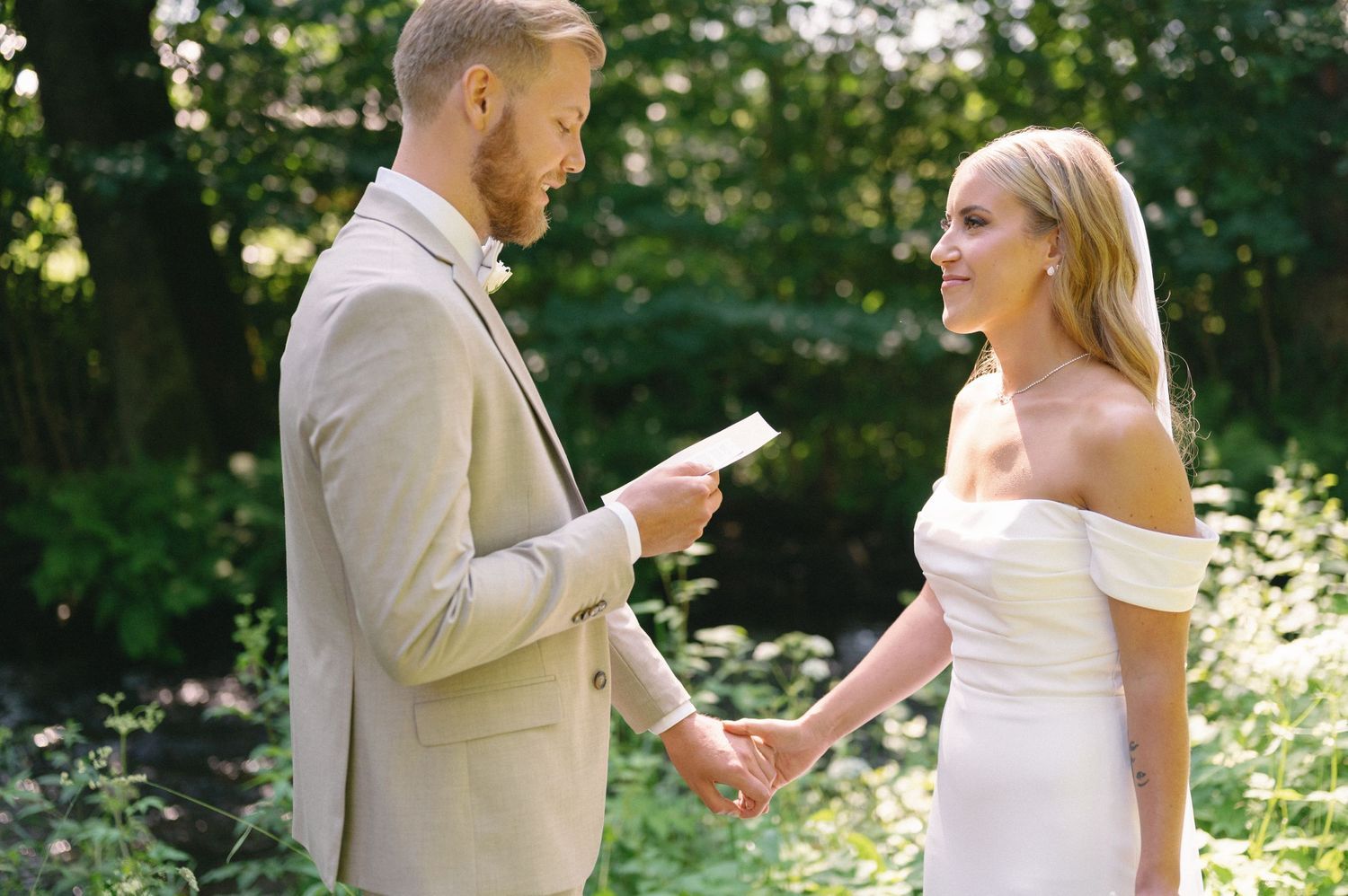 Couple exchanging vows in an outdoor garden ceremony.