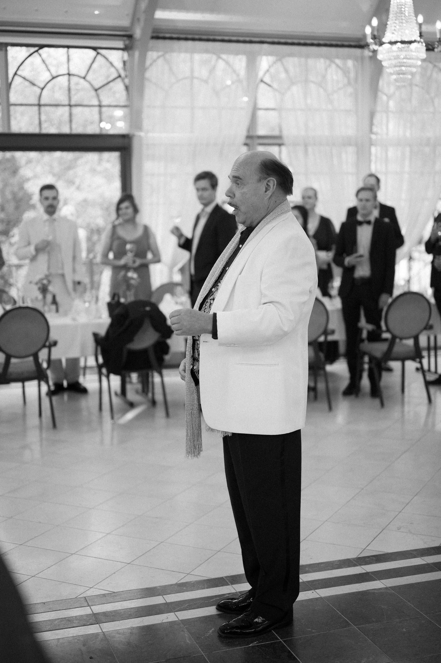 Black and white photo showing the dance floor and guests at an elegant wedding reception.