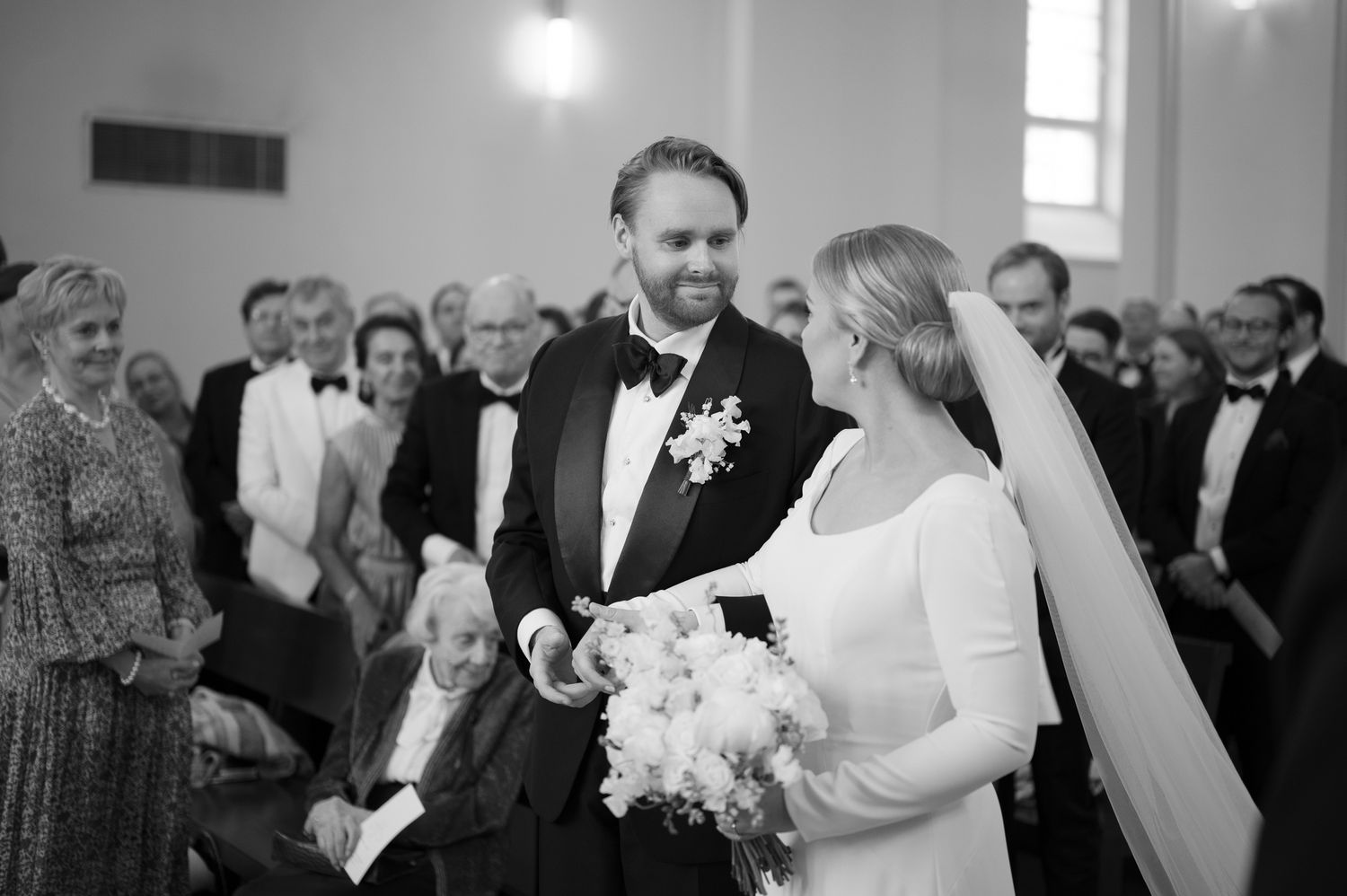 A joyful wedding ceremony moment in a bright church interior with the couple exchanging vows.