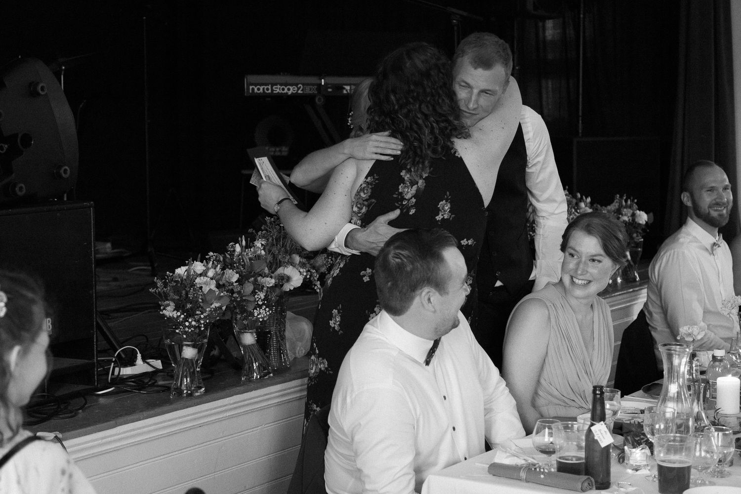 Black and white photo of wedding reception guests dining at tables.