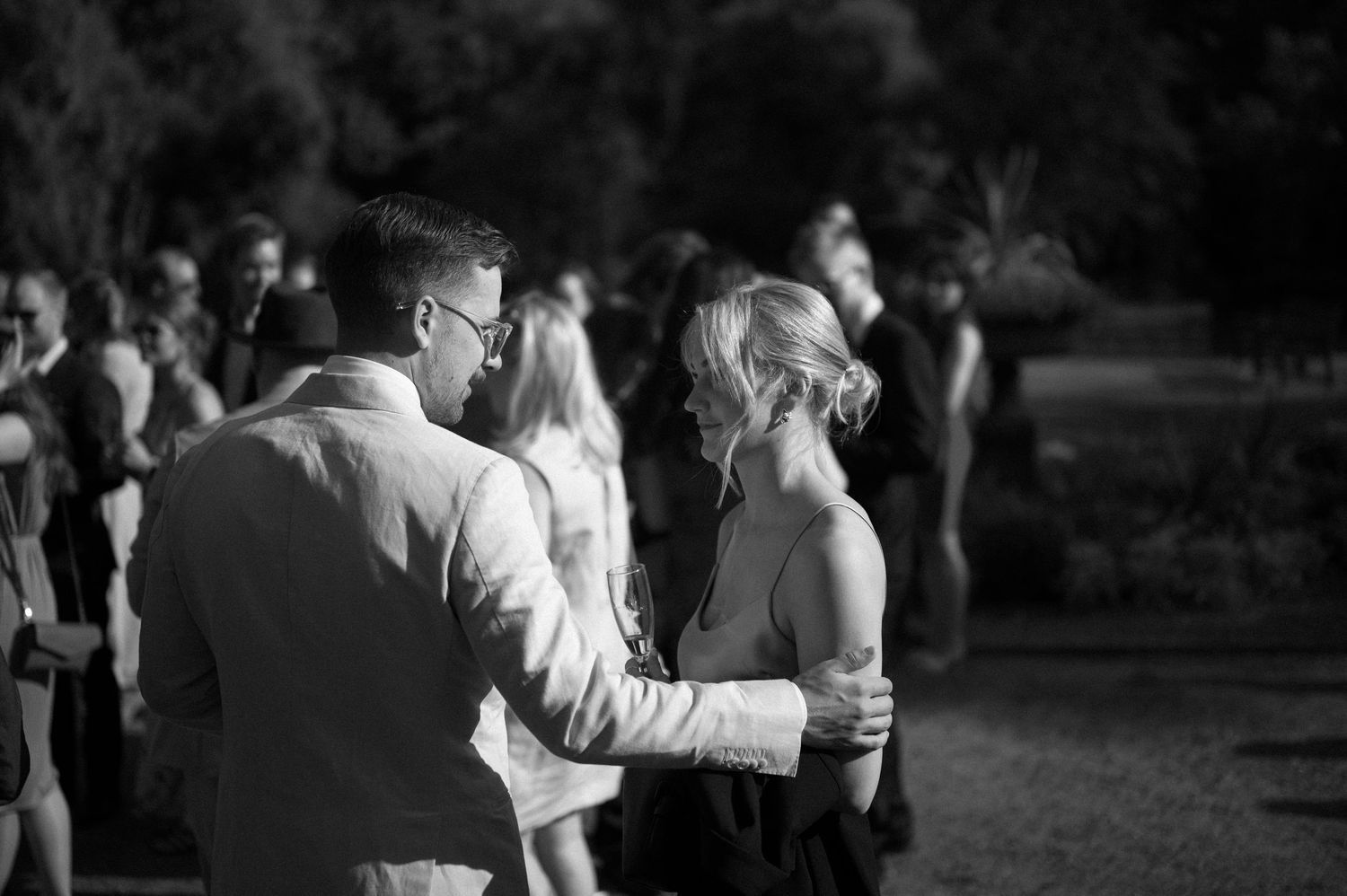 Black and white photo of couples dancing at an outdoor evening celebration.