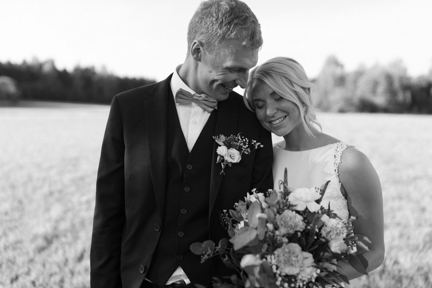 A series of black and white wedding photos showing intimate moments between a bride and groom in an outdoor setting.