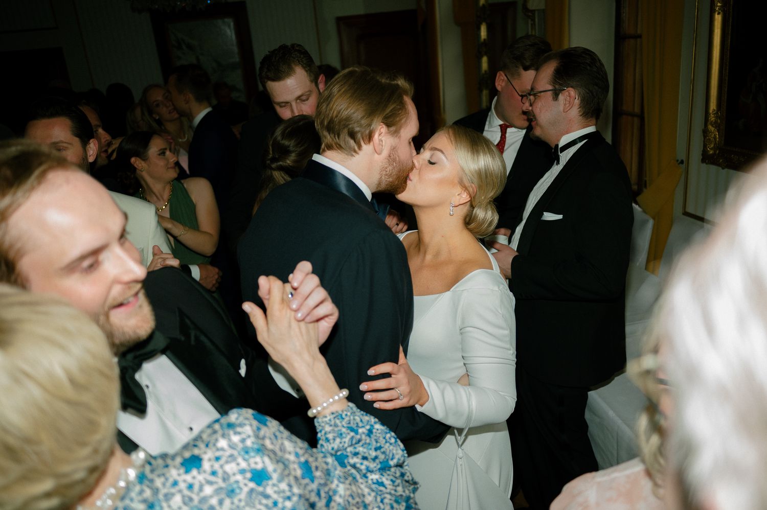 A series of wedding couples sharing romantic kisses at a formal reception celebration.