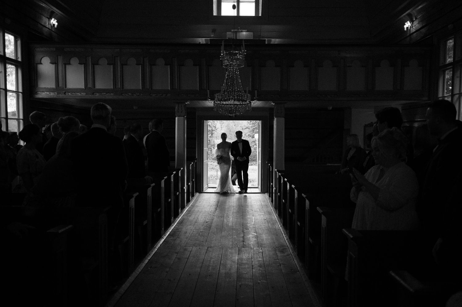 Dramatic silhouette of church interior with light streaming through doorway.