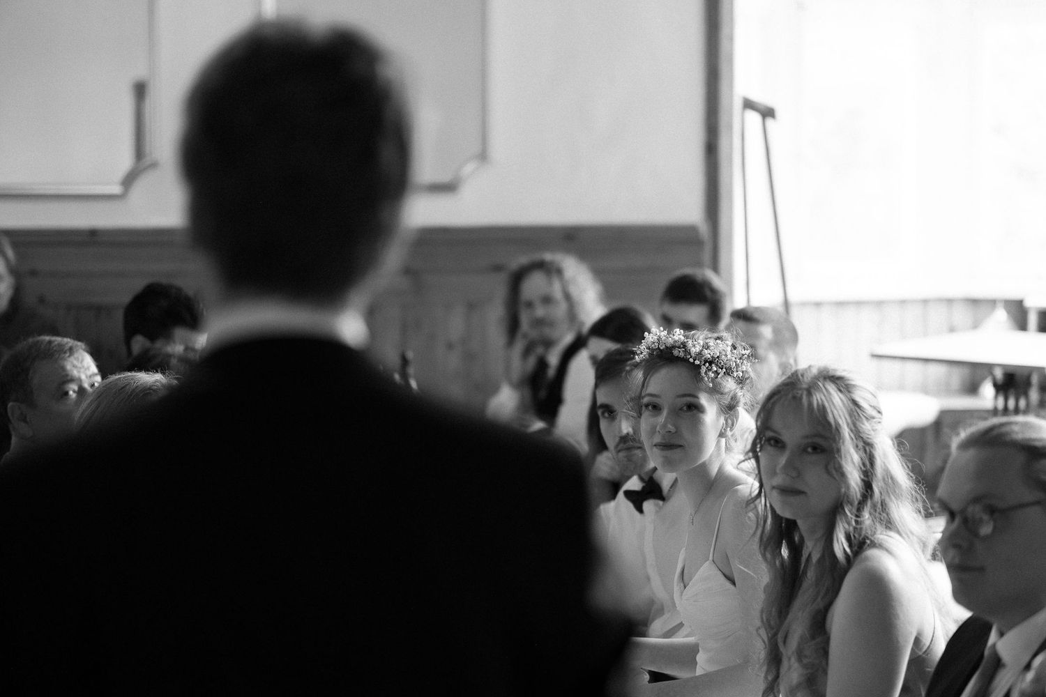 Wedding reception candid shot showing guests mingling in a naturally lit venue.