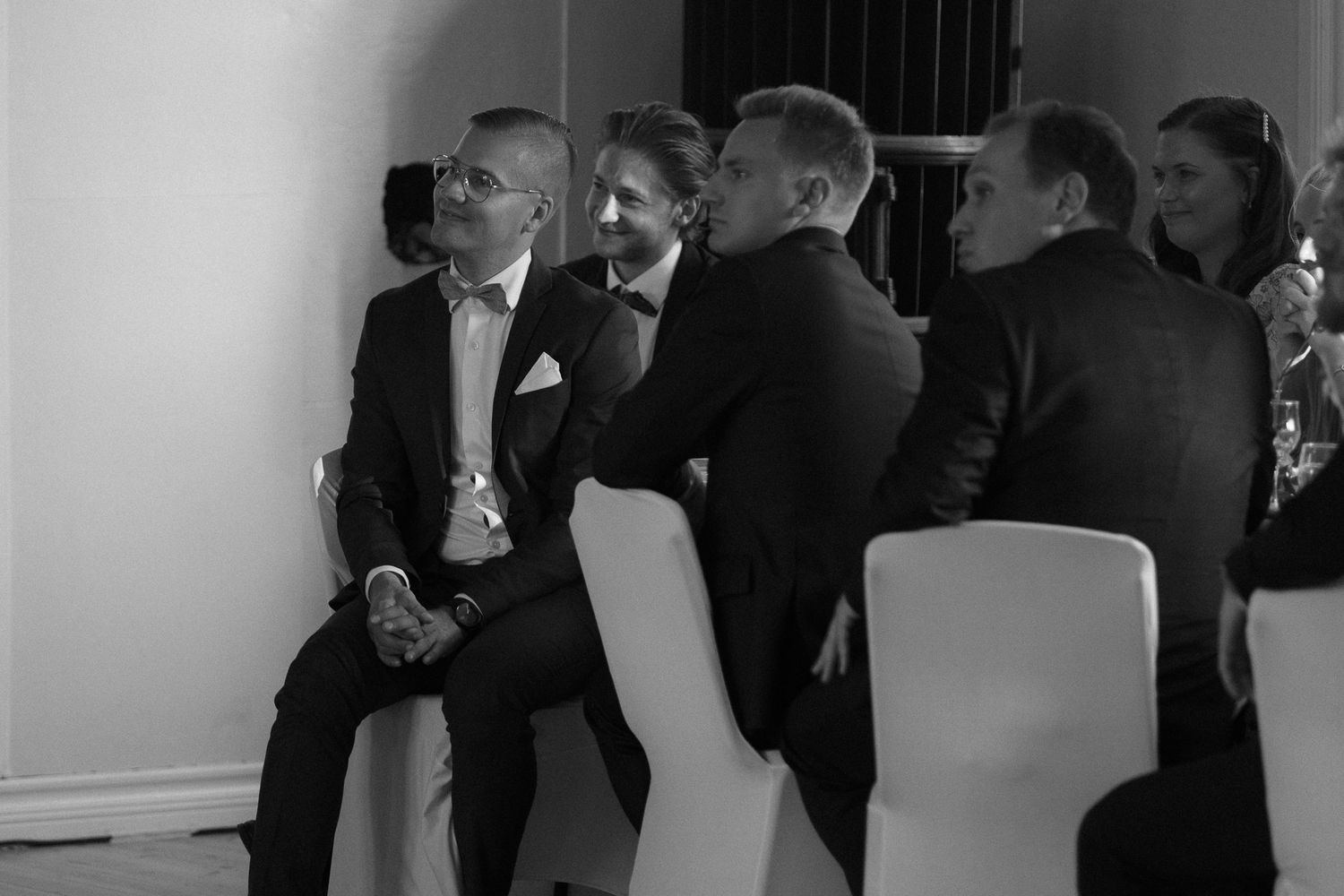 Wedding reception guests gather indoors for formal celebration.