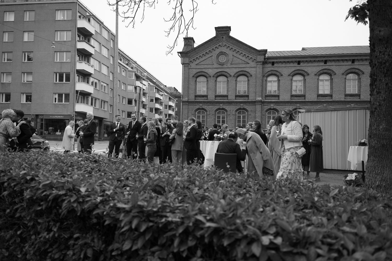 Historic black and white photographs show changing urban scenes with apartment buildings and crowds in a city setting.