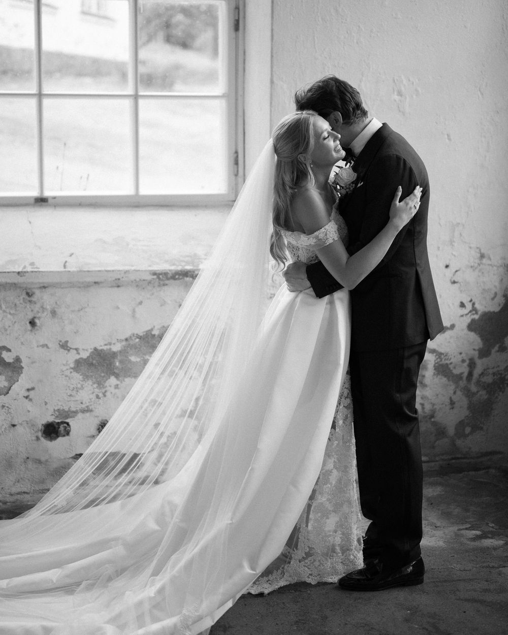 Dramatic black and white sequence of newlyweds dancing in rustic space.