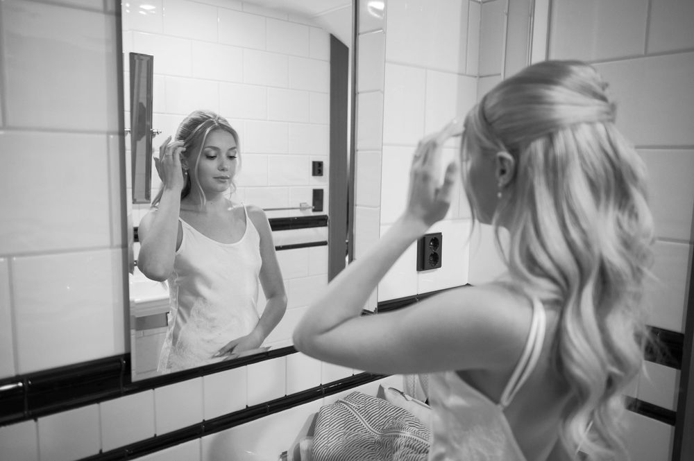 Person in light colored dress getting ready in bright bathroom.