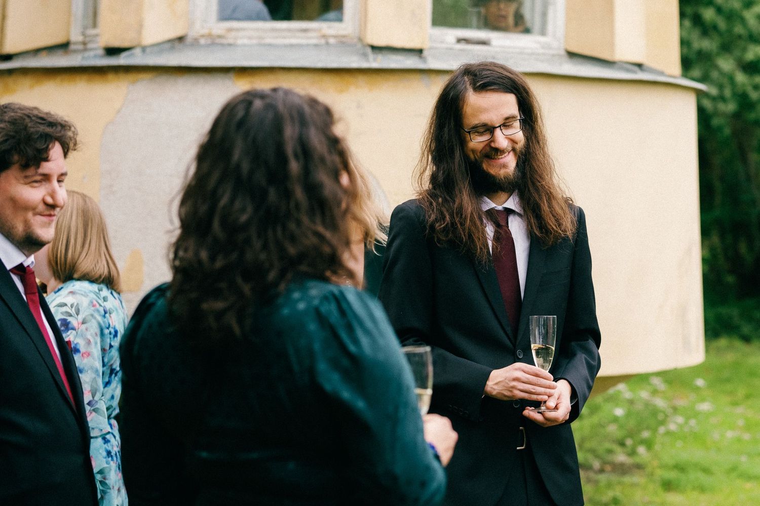 Outdoor social gathering with guests enjoying drinks and conversation.