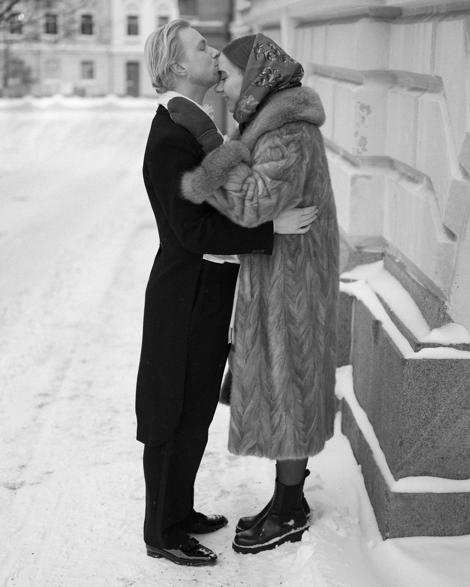 Vintage winter scene of a couple in formal wear embracing in the snow.