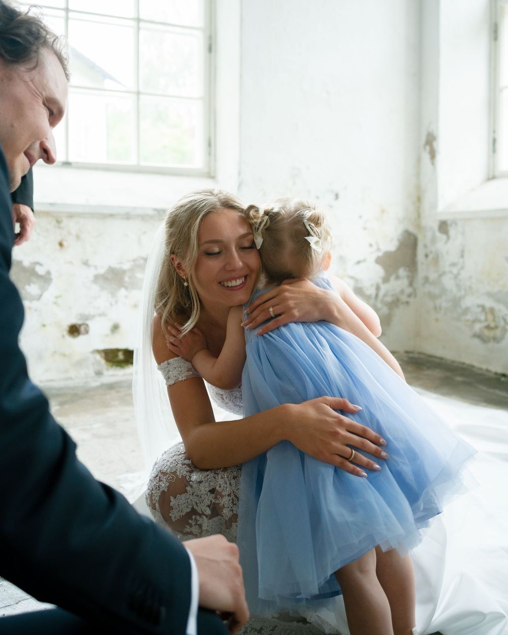 Tender embrace captured in a bright industrial space with soft natural lighting.