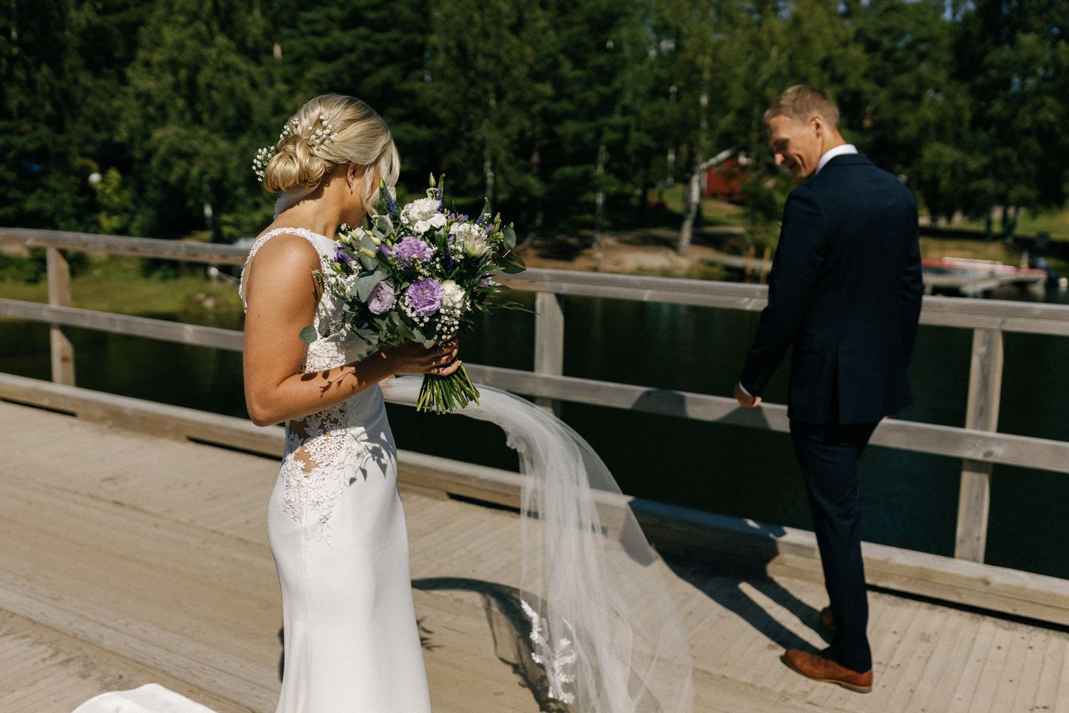 Wedding scene on a wooden boardwalk surrounded by pine trees.