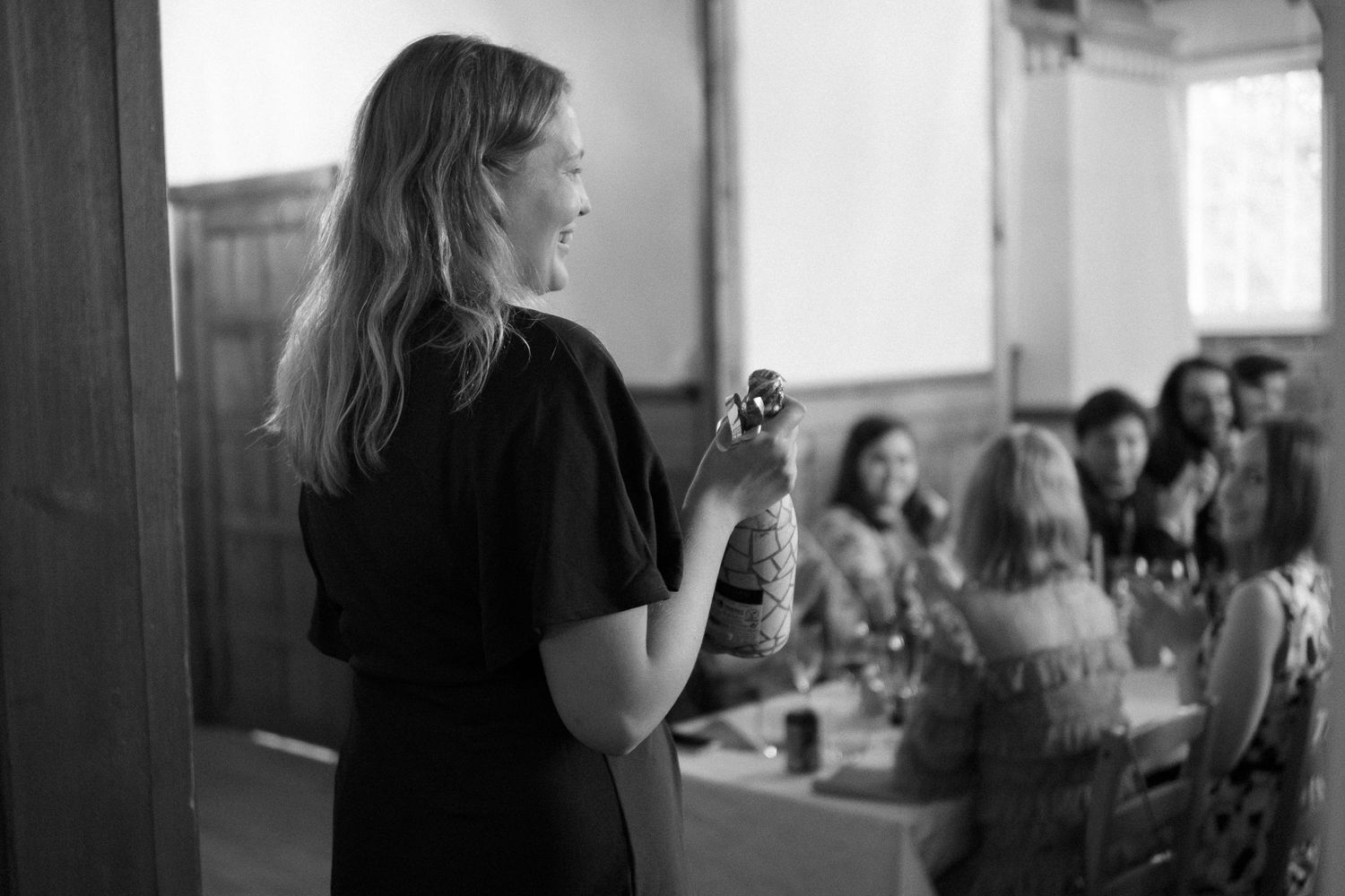 Black and white candid shots of wedding reception guests enjoying the celebration.