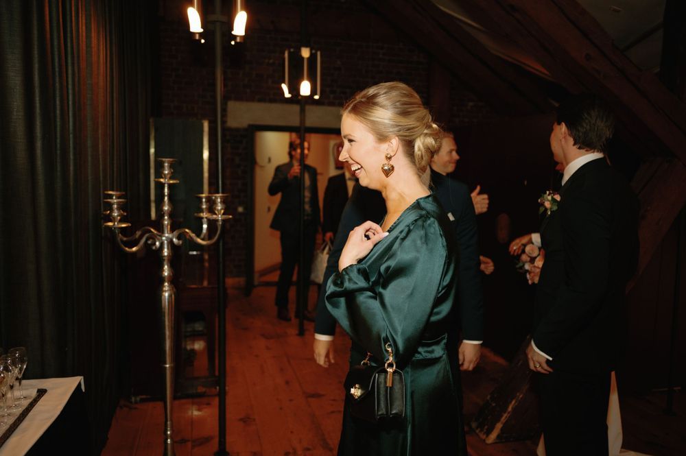 An elegant evening gathering in a dimly lit room with candelabras and formal attire.