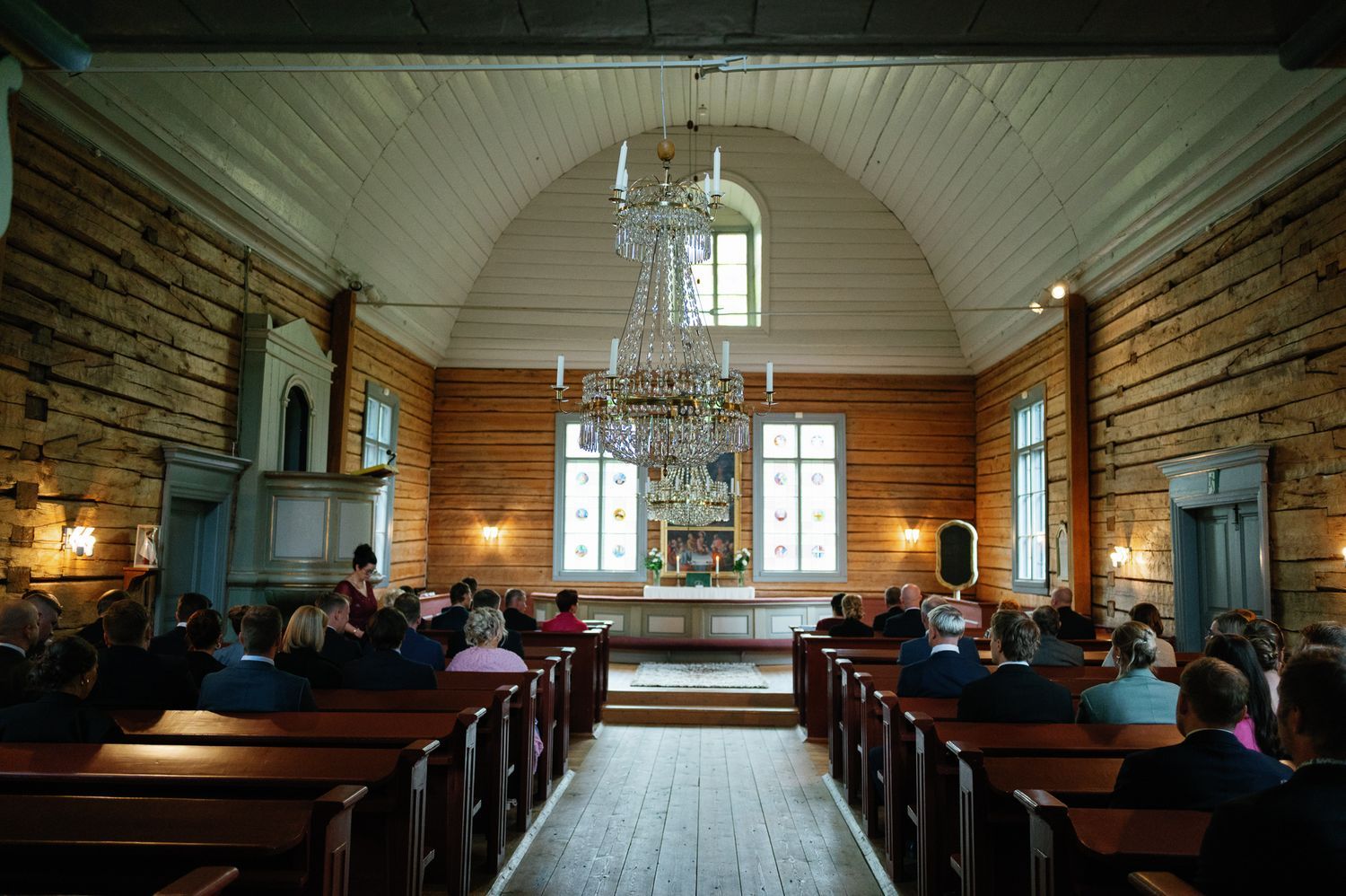 Interior of a traditional wooden church with vaulted ceiling and wooden pews.