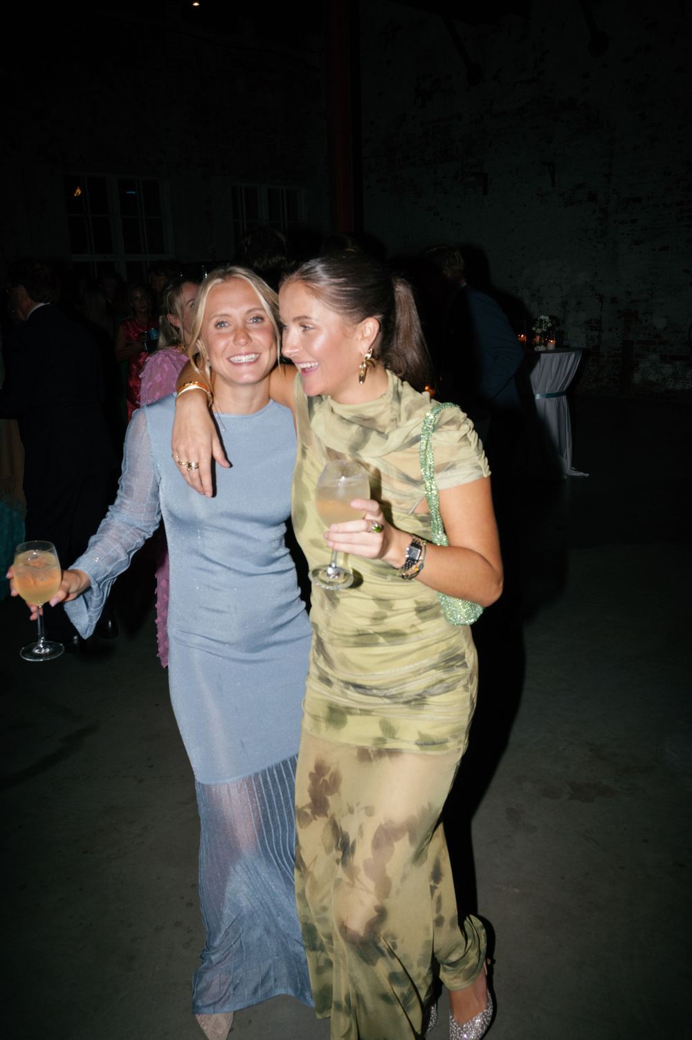 Party guests enjoying themselves on a dimly lit dance floor.