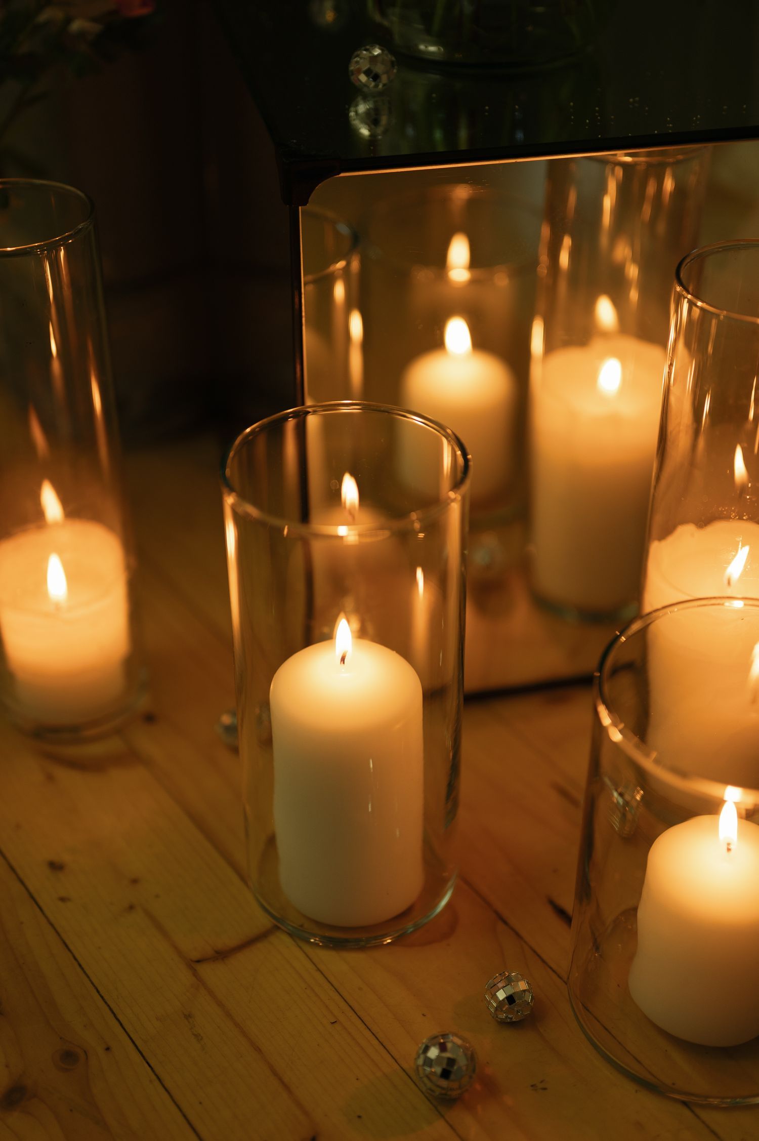 White pillar candles glowing warmly in glass holders create an intimate atmosphere.