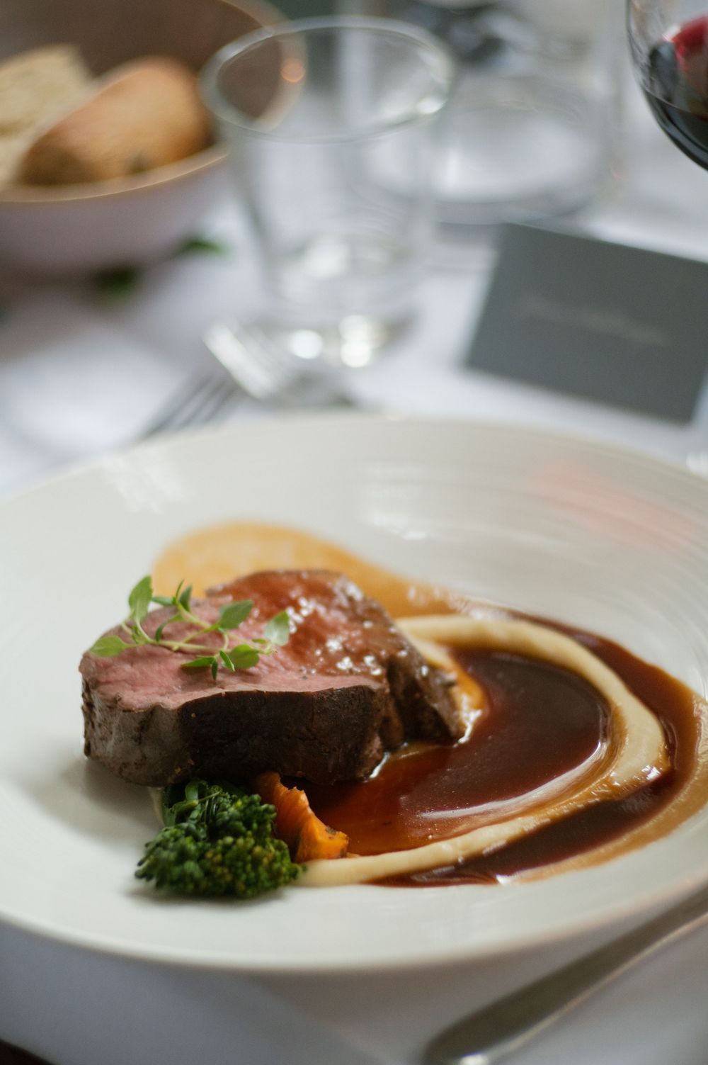 Plated gourmet beef dish with rich brown sauce served on white china.