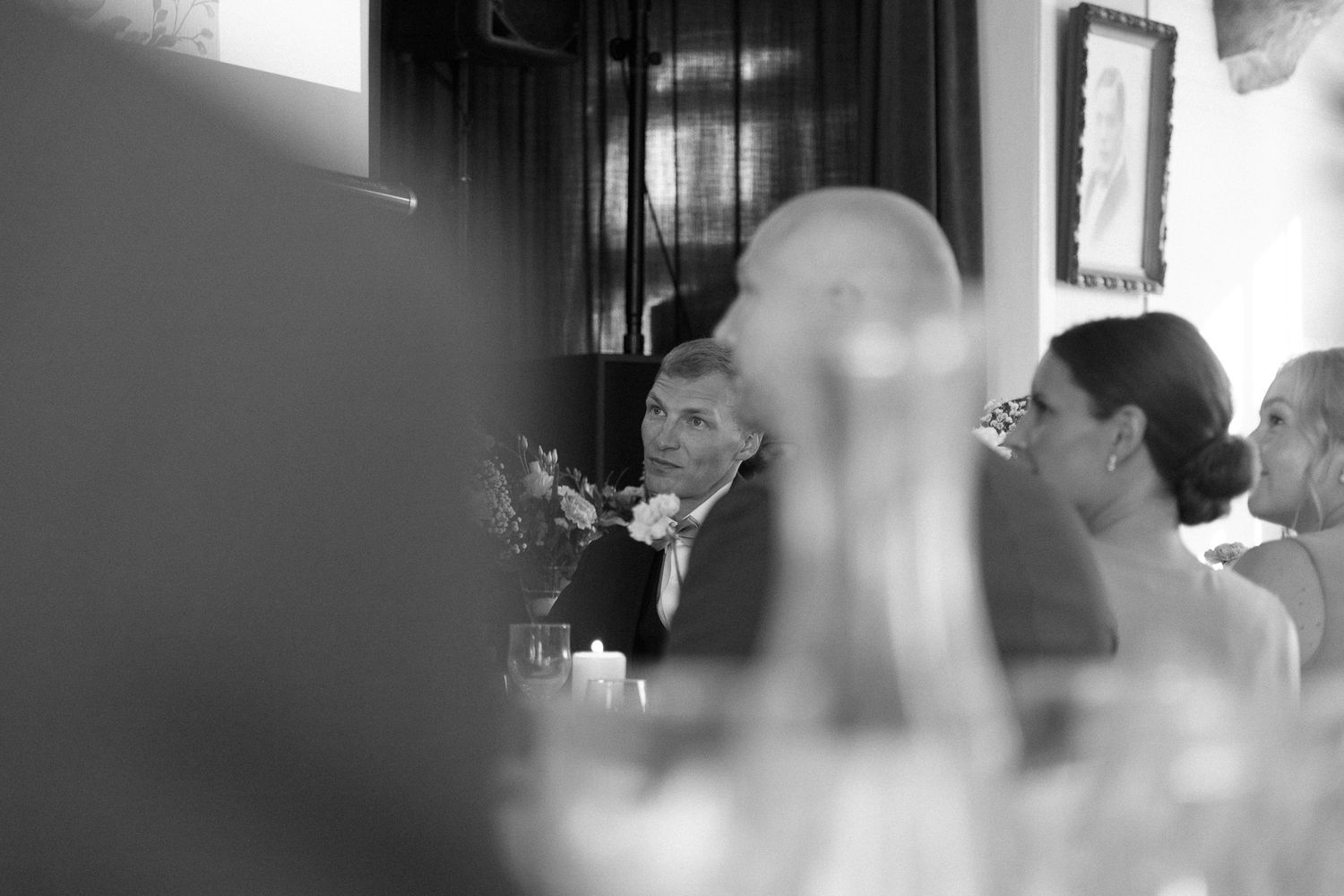 Black and white candid shot of guests during a formal event.
