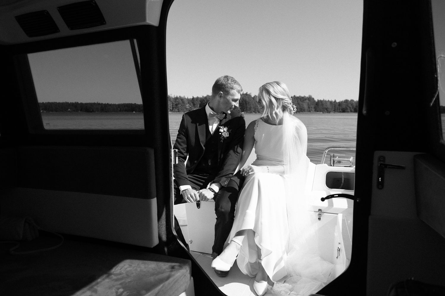 Interior view through a vehicle window of a couple on a boat dock.