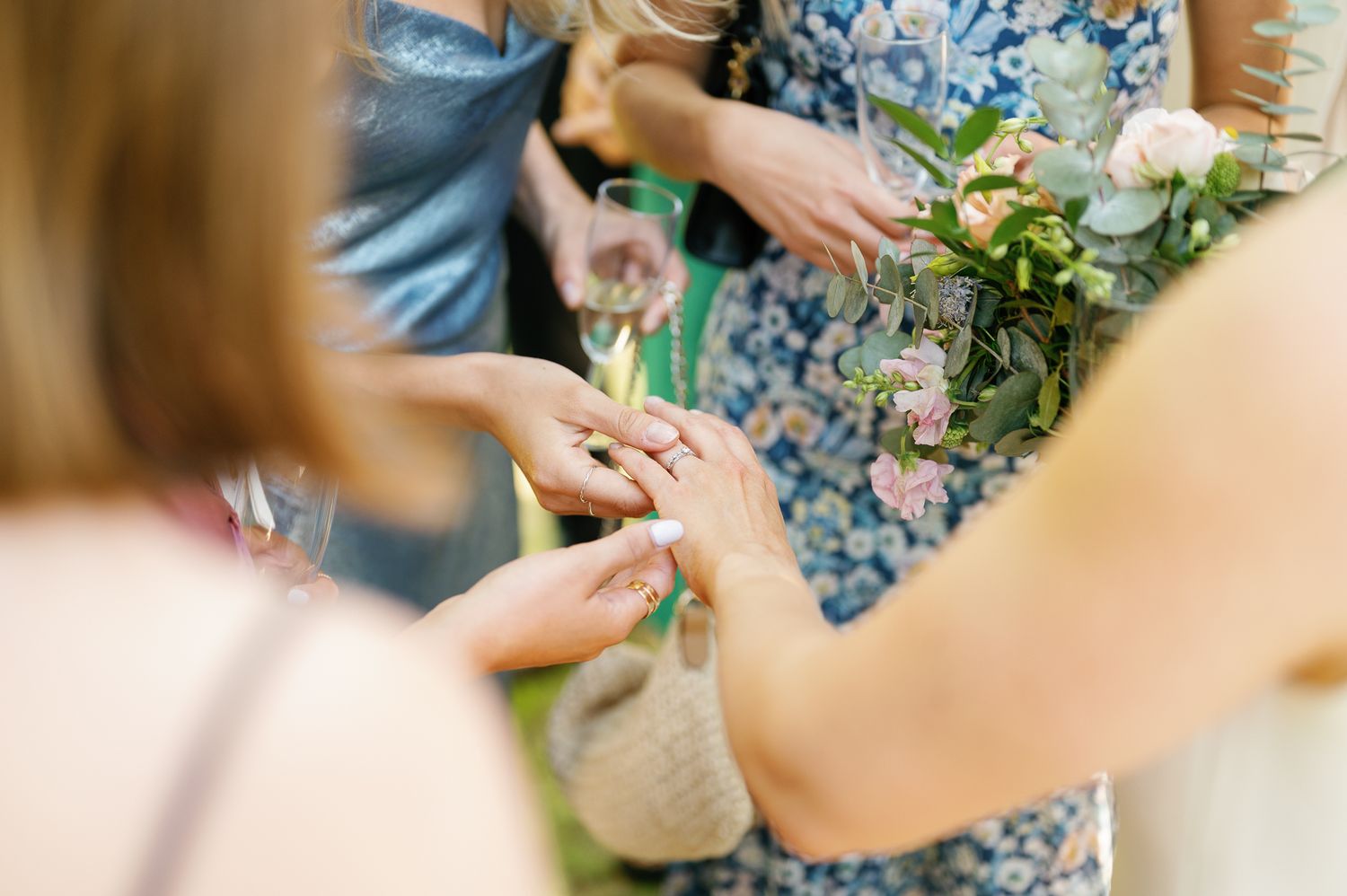 A close-up view of hands arranging delicate floral stems and greenery for a bouquet.