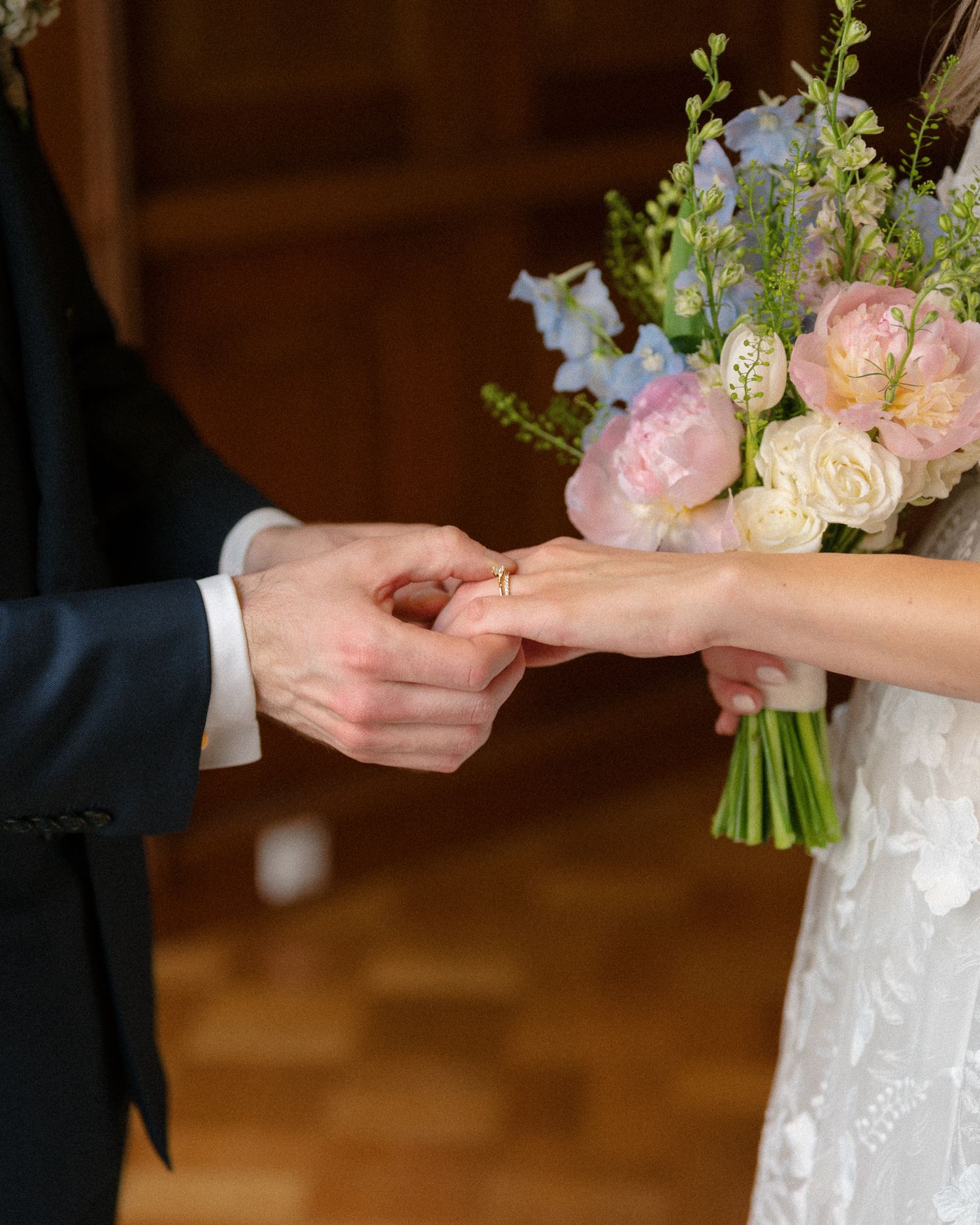 A close-up sequence showing hands exchanging wedding rings during a traditional ceremony.