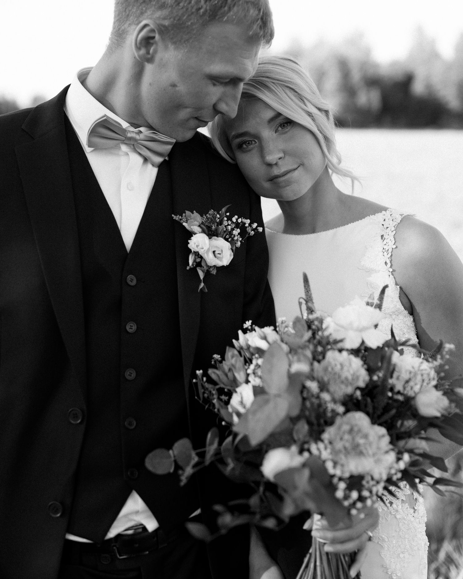 Romantic wedding portraits with white floral bouquet in natural lighting.