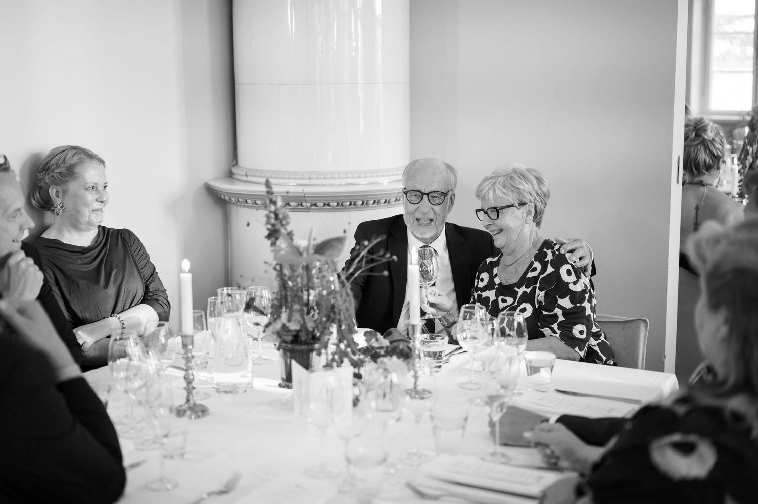 A series of black and white photographs showing people dining at an elegant table with wine glasses and formal place settings.