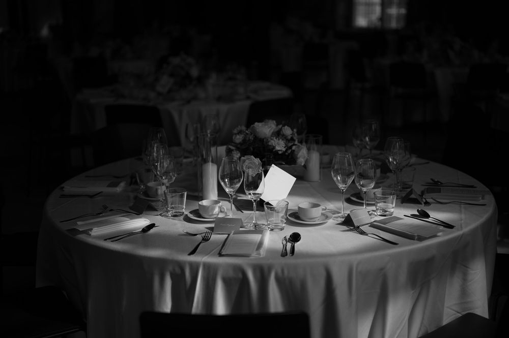 Romantic candlelit dinner tables set with white linens and wine glasses.