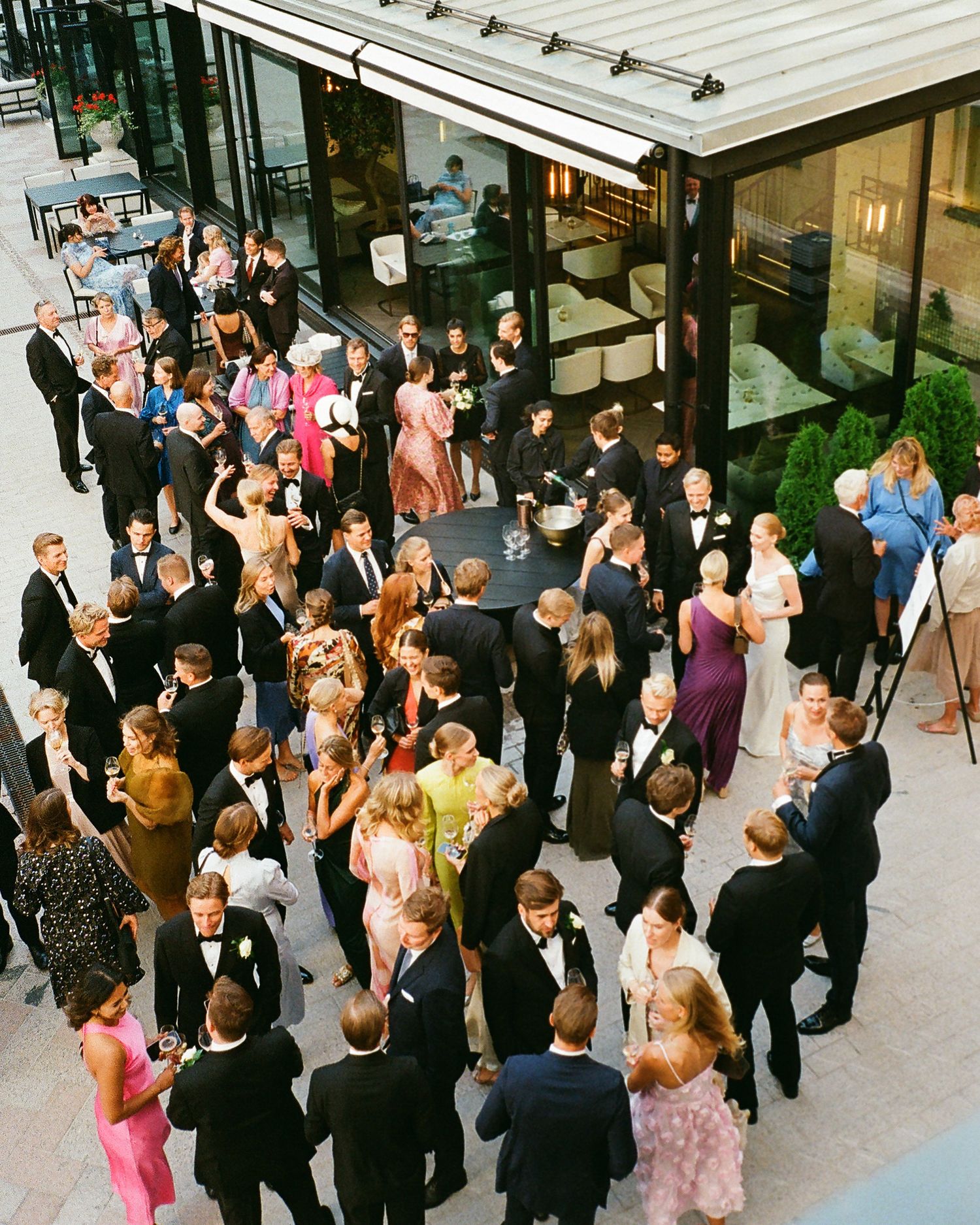 Large crowd of wedding guests mingling at an outdoor cocktail reception.