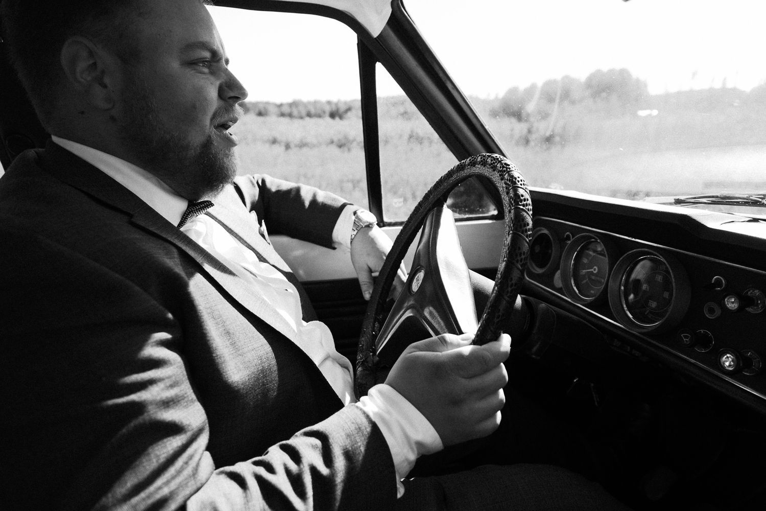 Black and white interior shots of car dashboard and steering wheel.