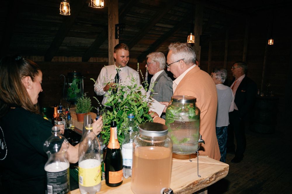 Lantern-lit reception space with guests gathering in a dimly lit rustic venue.