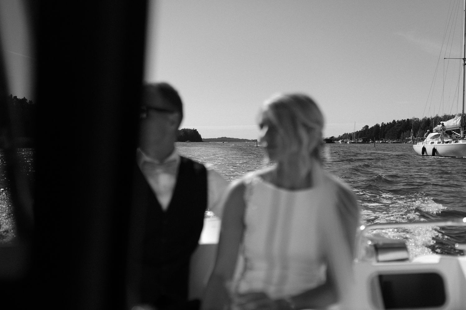 Black and white photograph of a couple sharing intimate moments on a boat.