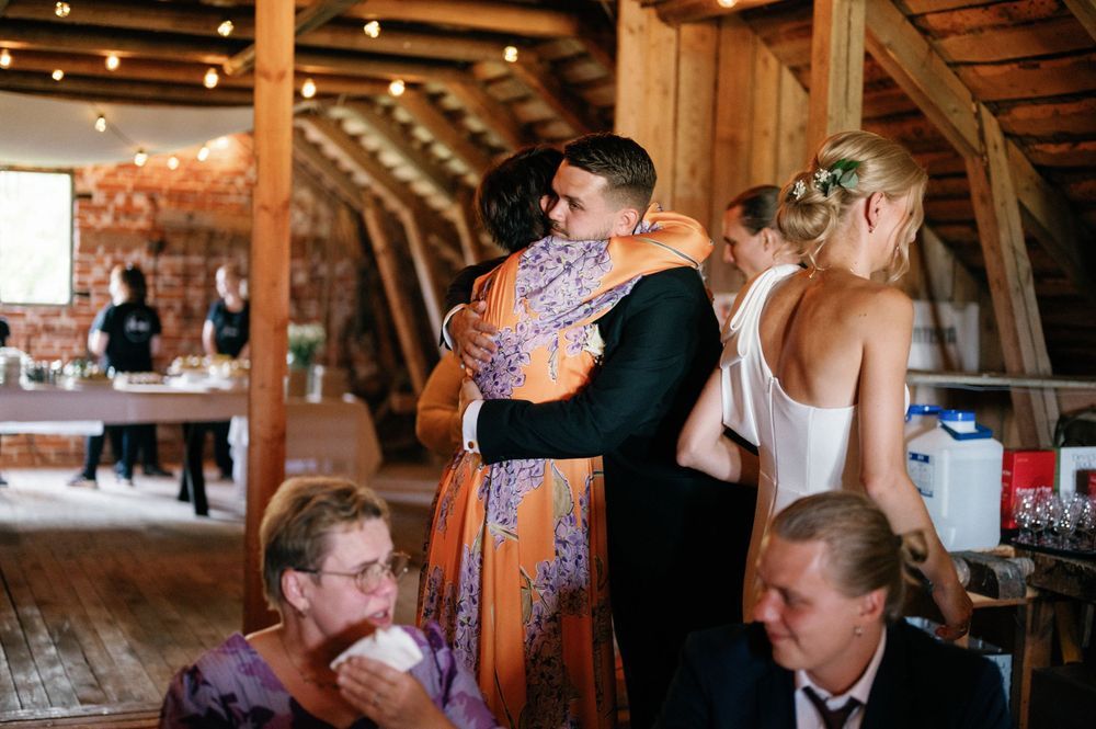 Wedding celebration in a rustic barn venue with decorative string lights and wooden beams.