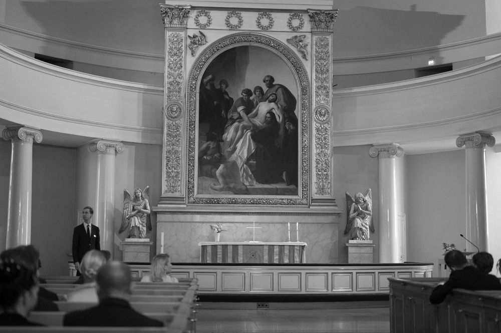 Interior of ornate church with decorative altar and classical architecture details.
