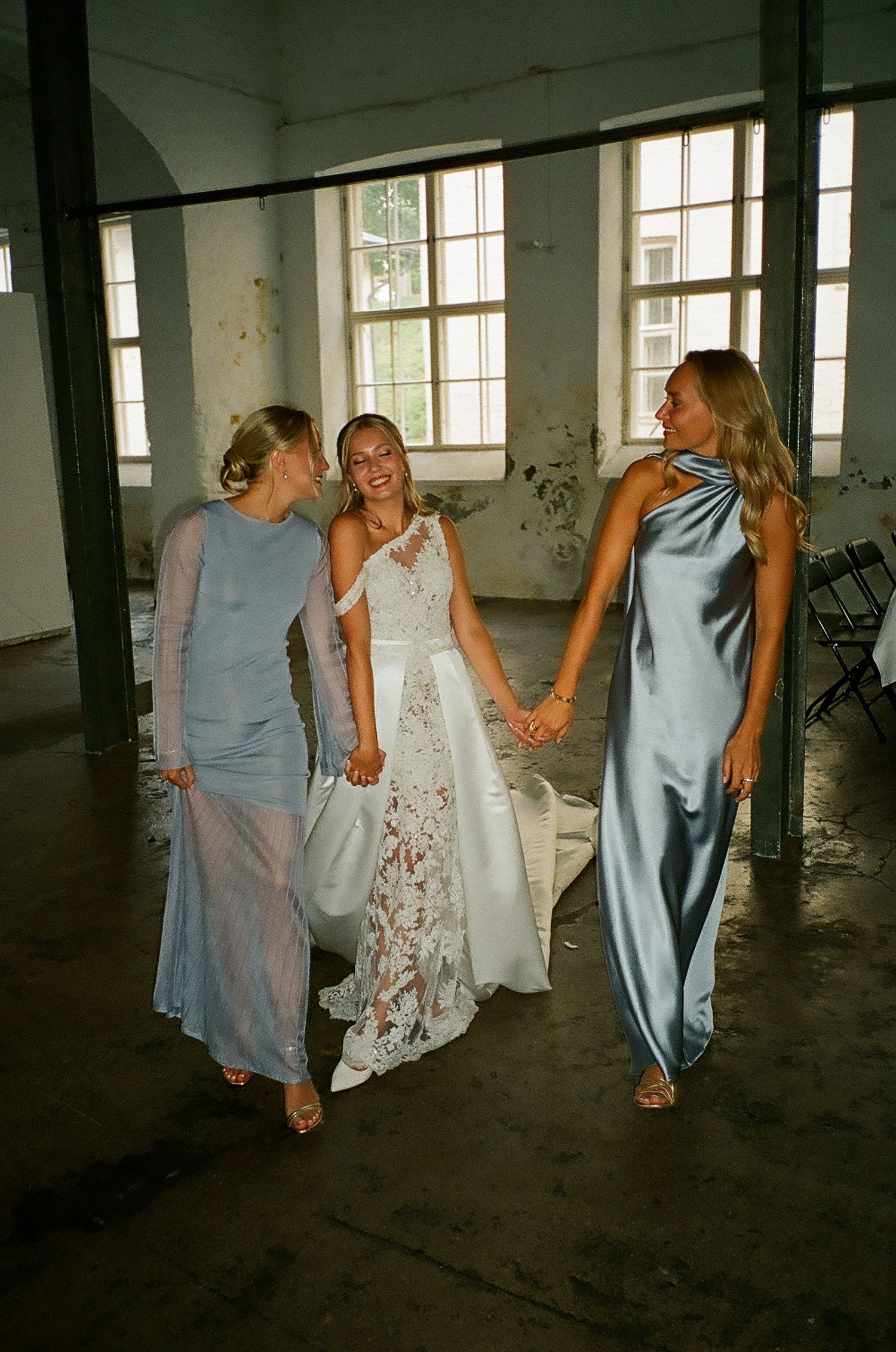 Group of women in blue and white dresses walking together in an industrial space.