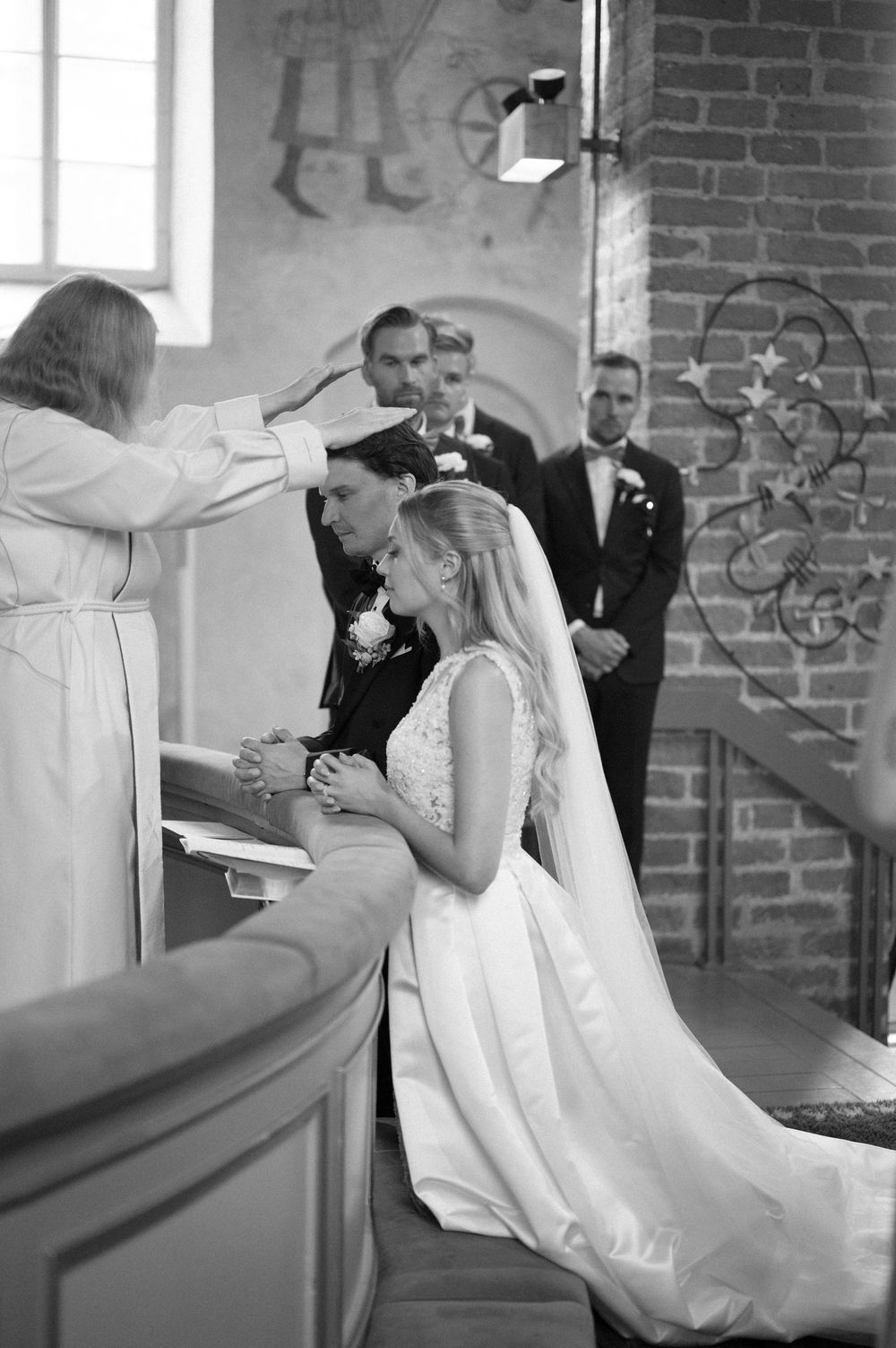A sequence of artistic black and white wedding photos in a brick-walled church.